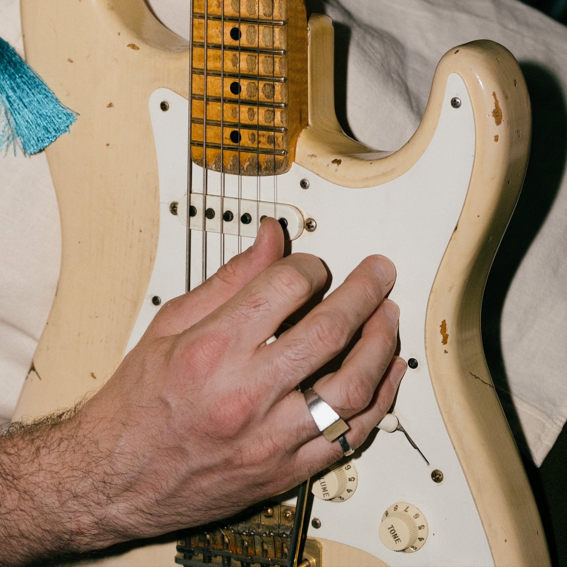 Close-up of a person playing an electric guitar with a blurred background